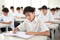 Teenage boys writing classroom student concentration. 