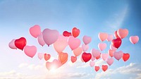 a real photo of heart-shaped balloons floating up in the air. 