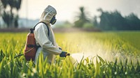 Asian farmer wear safety clothes with protective mask spraying organic pesticides. 