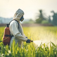 Asian farmer wear safety clothes with protective mask spraying organic pesticides. 