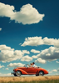 Photo of couple driving in red vintage car on countryside. 