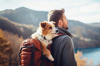 Photo of man travelling with his dog in a backpack. 