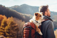 Photo of man travelling with his dog in a backpack. 