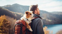 Photo of man travelling with his dog in a backpack. 