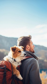 Photo of man travelling with his dog in a backpack. 