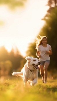 Photo of a dog running with owner at park.  