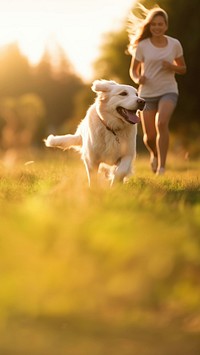 Photo of a dog running with owner at park.  