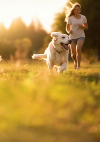 Photo of a dog running with owner at park.  