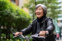 Senior asian woman riding a bicycle vehicle smile adult. AI generated Image by rawpixel.