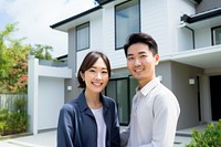 Asian couple standing smiling house. 