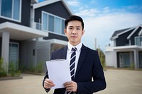 Asian man wearing suit holding clipboard standing house adult. 