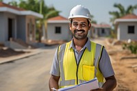 Indian man wearing hard hat holding clipboard standing hardhat helmet. 