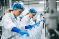 Two women wearing protective uniform factory laboratory working. 