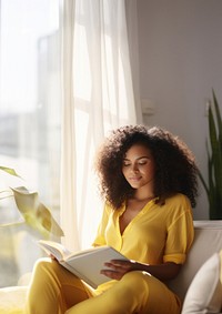 Photo of A relaxed trendy mixed-race african middle aged woman with long wavy hair with book.  