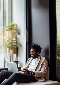 photo of happy african american man drink coffee while working laptop at home.  