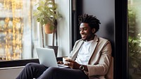 photo of happy african american man drink coffee while working laptop at home.  