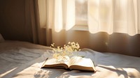 minimal photo of an open book sitting on top of a white sheet.  