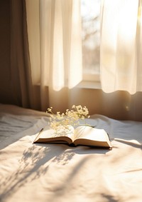 minimal photo of an open book sitting on top of a white sheet.  