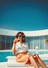 photo of a women with summer outfits sitting next to the luxury modern pool.  