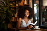 A dark-skinned woman reading adult book. 