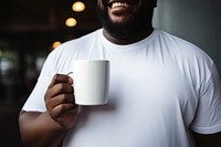 Mug t-shirt holding coffee. 