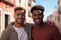 Gay couple laughing outdoors smiling. 