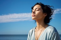 photo of woman praying with bluesky on the sea with blurred vision.  