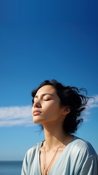 photo of woman praying with bluesky on the sea with blurred vision.  