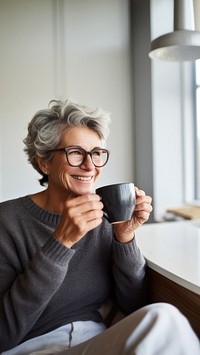 Product photography of a mature woman drinking black coffee while reading newspaper.  