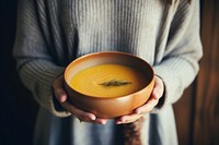 Pumpkin soup bowl holding pumpkin. 