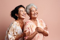 Old native women using skincare cream laughing adult togetherness. 