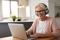 Senior business woman having videocall meeting headphones computer glasses. 