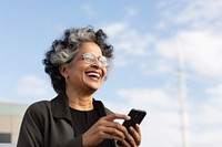 Senior indian business woman using smartphone facetiming laughing glasses smile. 