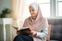 Senior woman wearing hijab reading a book sitting adult spirituality. AI generated Image by rawpixel.