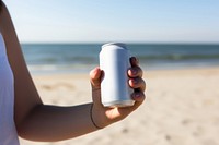 Beach outdoors holding drink. 