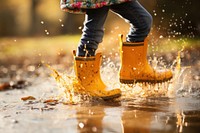 Kid playing with water, rain boots photo. .