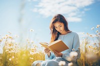 Reading a book sitting female adult. 