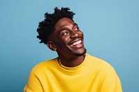 A black young man look away laughing yellow person. 