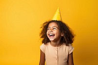 Girl wearing party hat laughing yellow child. 