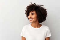 Smiling person with curly hair wearing a white shirt against a plain background. The person is looking to the side, exuding a joyful and relaxed vibe.