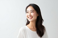 Smiling woman in a white shirt against a plain background. The woman has long dark hair and a cheerful expression. Bright smile and joyful demeanor.