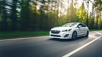 A photo of white EV car Moving Through Highway.  