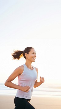 a portrait photo of a happy athletic woman jogging at sunrise by the beach.  