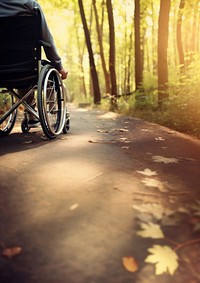 photo Close-up of a person's of Leg disabled hand maneuvering a wheelchair along a forest trail.  