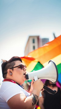 photo of plus size mexican lesbian woman using a megaphone at a pride parade.  