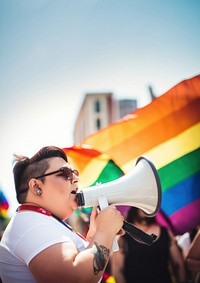 photo of plus size mexican lesbian woman using a megaphone at a pride parade.  