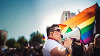 photo of plus size mexican lesbian woman using a megaphone at a pride parade.  