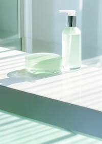 Minimalist skincare setup with a translucent bottle and a round soap dish. Soft lighting highlights the clean, modern design of the skincare products.