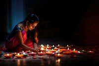 close up shot of Indian woman hand lighting diyas on Rangoli decorations on floor in Diwali festival. AI generated Image by rawpixel.