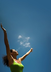 photo of mid-ages woman stretch the arms with bluesky and sun the green natual with blurred visio.  